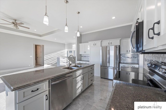 kitchen featuring white cabinets, stainless steel appliances, and an island with sink