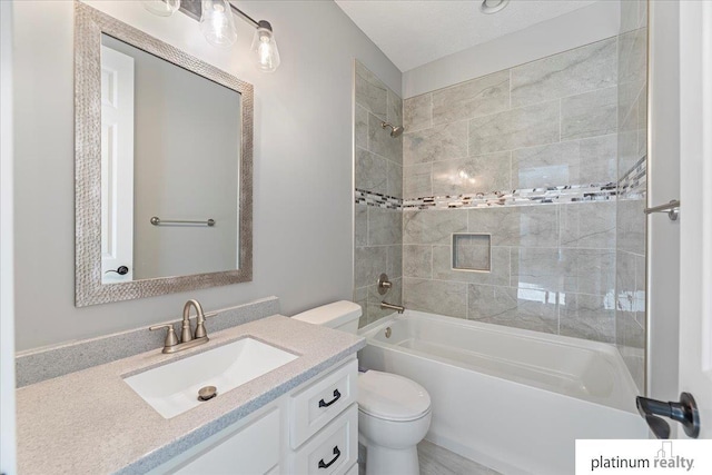 full bathroom with vanity, tiled shower / bath combo, and toilet