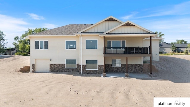 rear view of house with a garage and a balcony