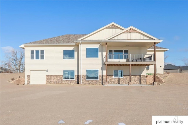 rear view of house featuring a garage and a balcony