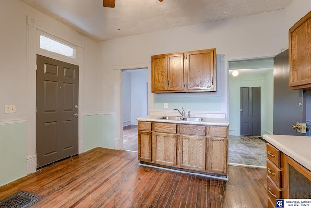 kitchen featuring ceiling fan, sink, and dark wood-type flooring