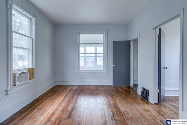 spare room featuring cooling unit and dark hardwood / wood-style floors