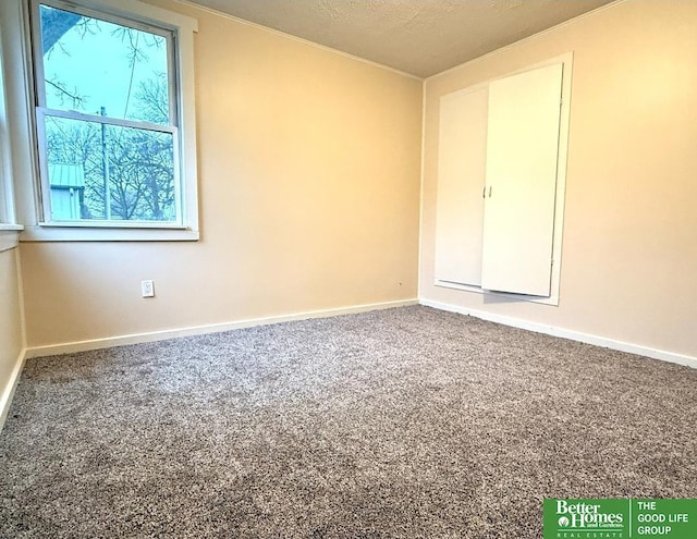 carpeted spare room featuring a textured ceiling