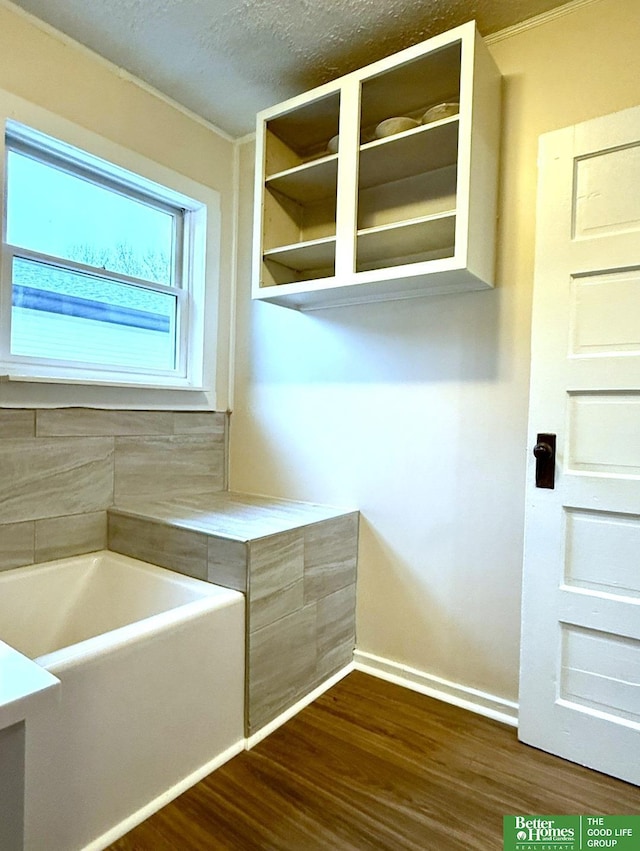 interior space with a washtub, hardwood / wood-style floors, and a textured ceiling