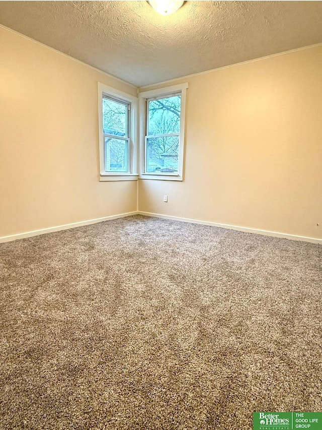 carpeted empty room featuring a textured ceiling