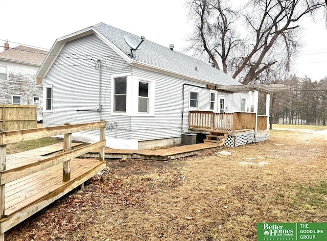 rear view of property with a wooden deck and cooling unit