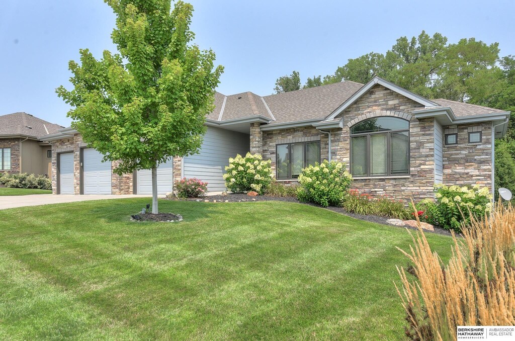 ranch-style house featuring a front lawn and a garage