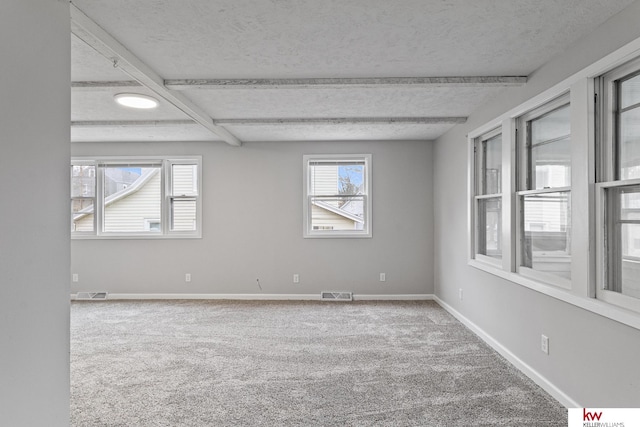 carpeted spare room with beam ceiling and a textured ceiling