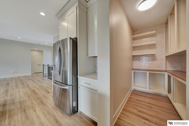 kitchen with white cabinetry, stainless steel fridge with ice dispenser, and light wood-type flooring