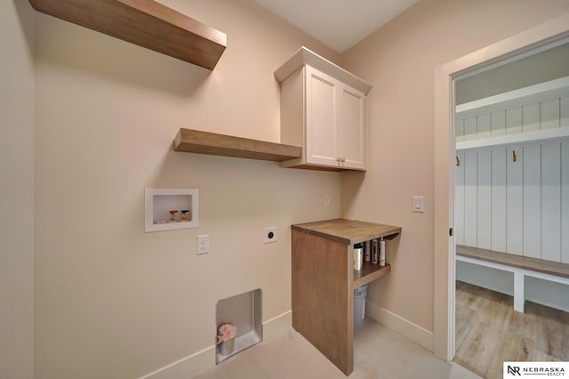 clothes washing area with hookup for an electric dryer, cabinets, and washer hookup