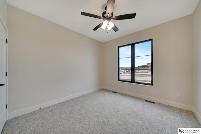 carpeted spare room with ceiling fan