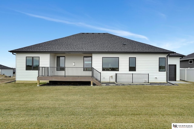 rear view of property with a lawn and a wooden deck