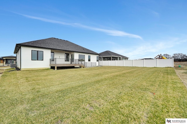 rear view of property with a yard and a wooden deck