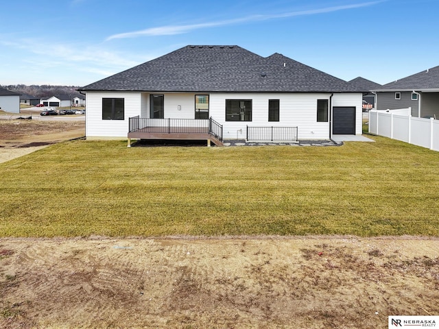 rear view of property featuring a yard and a deck