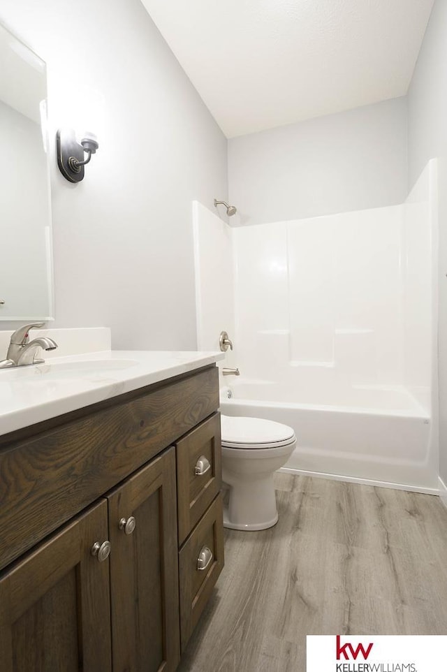 1450 Montana St, Superior, NE 68978 - bathroom featuring wood finished floors, vanity, toilet, and tub / shower combination