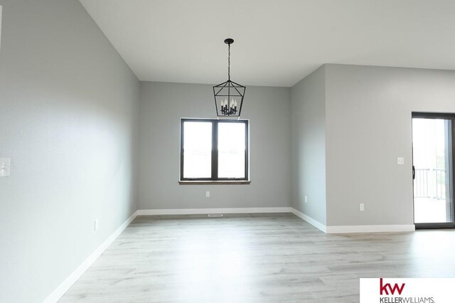 1450 Montana St, Superior, NE 68978 - empty room with a chandelier, light wood-type flooring, and baseboards