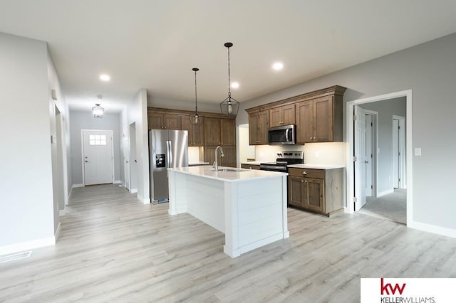 1450 Montana St, Superior, NE 68978 - kitchen with stainless steel appliances, baseboards, light wood-type flooring, light countertops, and a center island with sink