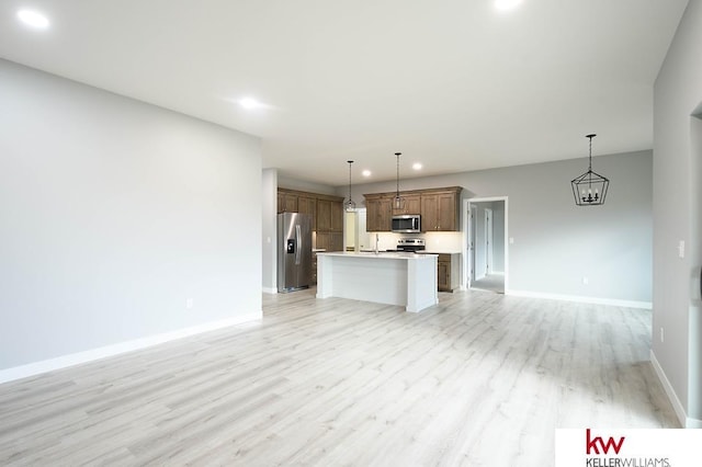 1450 Montana St, Superior, NE 68978 - kitchen featuring stainless steel appliances, open floor plan, baseboards, light wood-type flooring, and light countertops