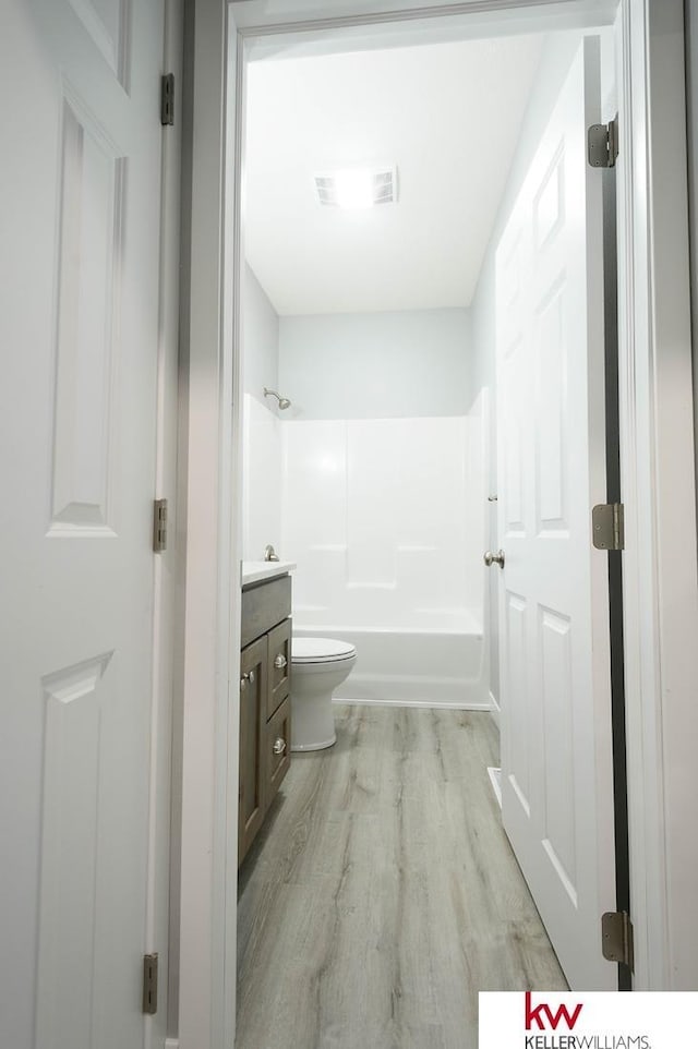 1450 Montana St, Superior, NE 68978 - bathroom featuring wood finished floors, toilet, vanity, and bathtub / shower combination