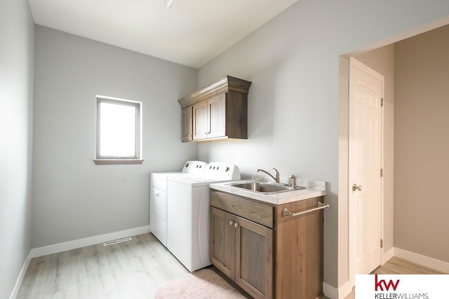 1450 Montana St, Superior, NE 68978 - washroom with cabinet space, washer and dryer, light wood-style flooring, and baseboards