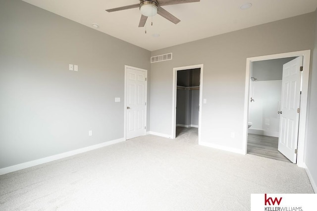 1450 Montana St, Superior, NE 68978 - unfurnished bedroom featuring light carpet, baseboards, a walk in closet, a closet, and ensuite bath