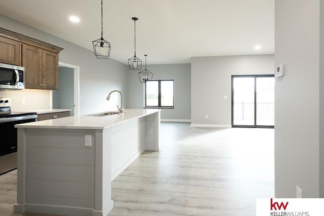 1450 Montana St, Superior, NE 68978 - kitchen featuring appliances with stainless steel finishes, a sink, light wood-style floors, recessed lighting, and a center island with sink