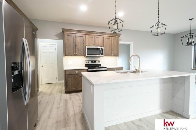1450 Montana St, Superior, NE 68978 - kitchen with stainless steel appliances, a sink, light wood-style flooring, baseboards, and hanging light fixtures