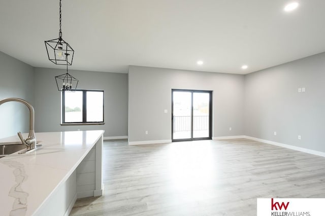 1450 Montana St, Superior, NE 68978 - unfurnished living room with light wood-style floors, healthy amount of natural light, a sink, recessed lighting, and baseboards
