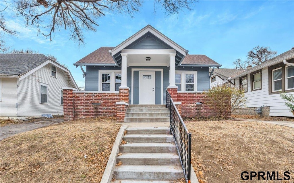 bungalow-style home with a front lawn