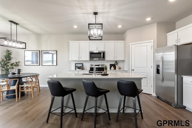 kitchen featuring white cabinets, an island with sink, and stainless steel appliances