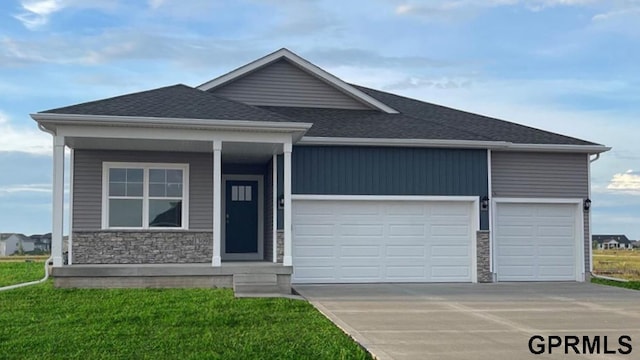 view of front of home with a porch, a garage, and a front yard