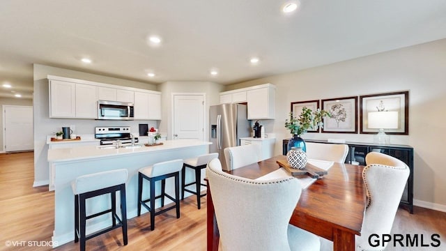 dining room featuring sink and light hardwood / wood-style floors