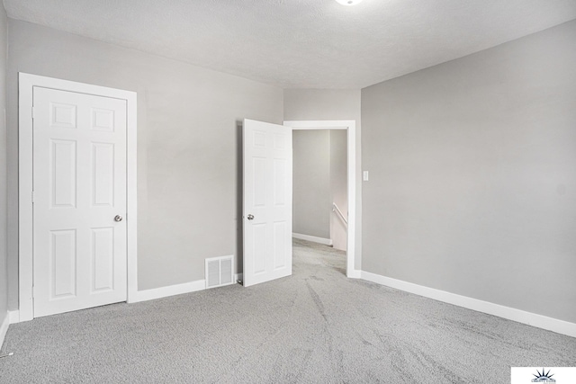 unfurnished bedroom featuring a textured ceiling and carpet floors