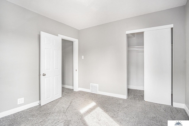 unfurnished bedroom with light colored carpet and a closet