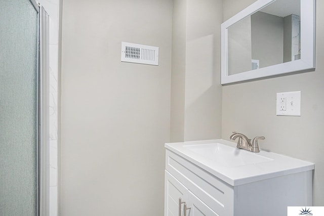 bathroom with vanity and a shower with shower door