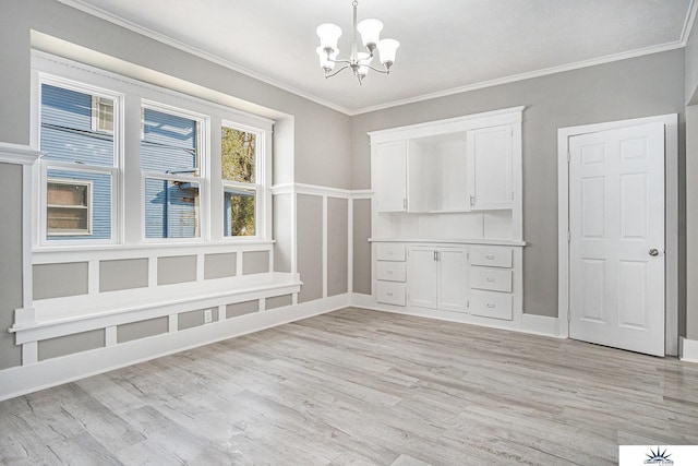 interior space with a chandelier, light wood-type flooring, and crown molding