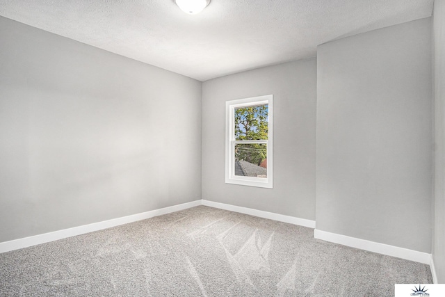 carpeted empty room with a textured ceiling