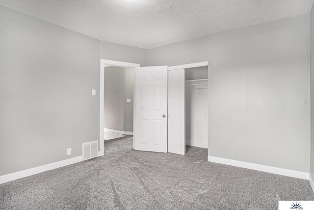 unfurnished bedroom featuring carpet, a textured ceiling, and a closet