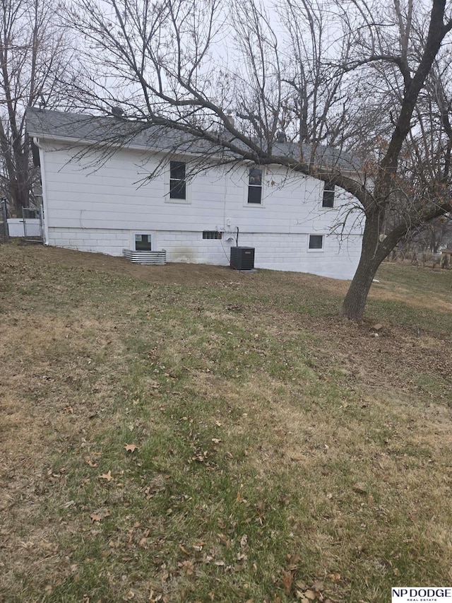 view of side of property with a yard and cooling unit