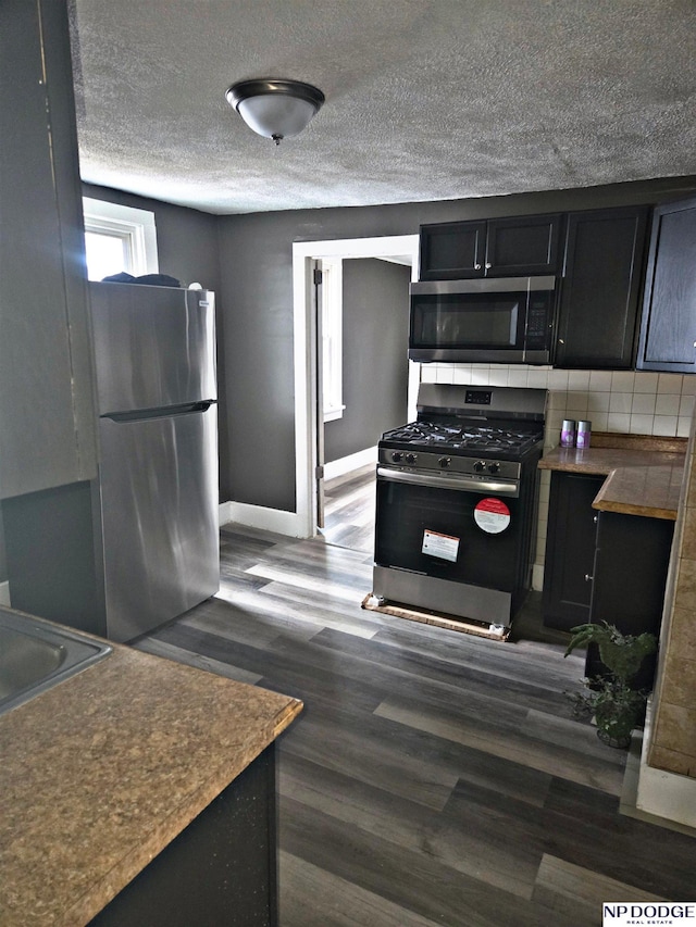 kitchen featuring backsplash, dark hardwood / wood-style floors, sink, and stainless steel appliances