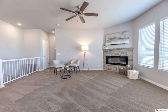 unfurnished room featuring carpet floors, ceiling fan, and a fireplace