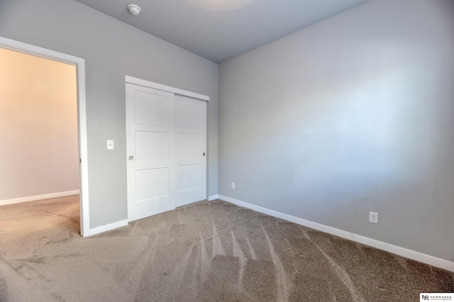 unfurnished bedroom featuring carpet flooring and a closet