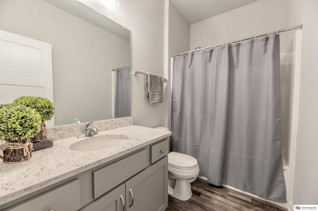 bathroom featuring curtained shower, toilet, vanity, and hardwood / wood-style flooring