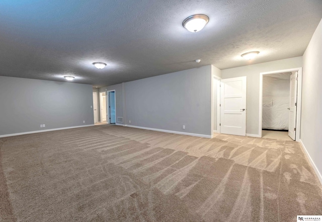 basement featuring a textured ceiling and light carpet