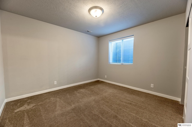 carpeted empty room with a textured ceiling