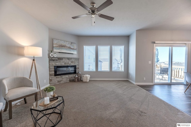 living room with ceiling fan and a fireplace