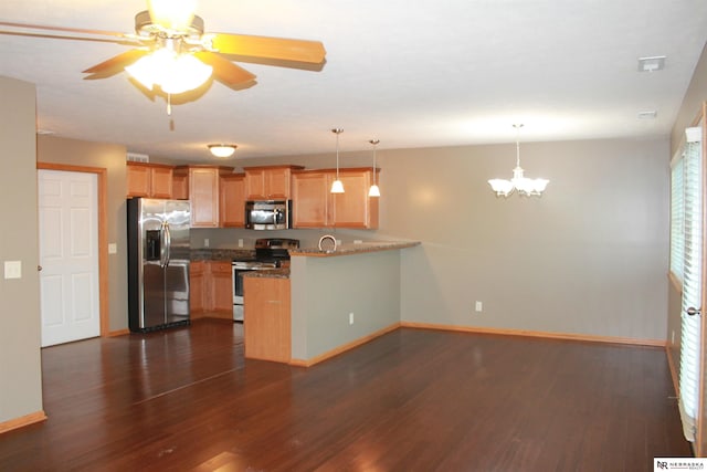 kitchen featuring dark wood-type flooring, sink, decorative light fixtures, kitchen peninsula, and stainless steel appliances