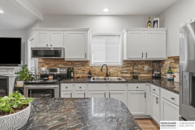 kitchen with white cabinets, stainless steel appliances, tasteful backsplash, and sink