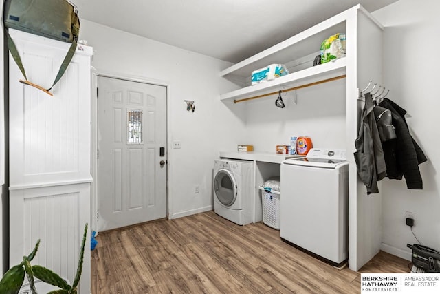 clothes washing area featuring light wood-type flooring and washer and clothes dryer