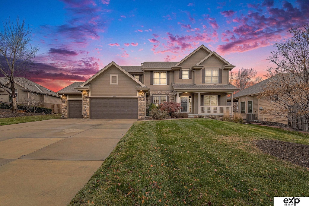 craftsman house with a lawn, a porch, and a garage